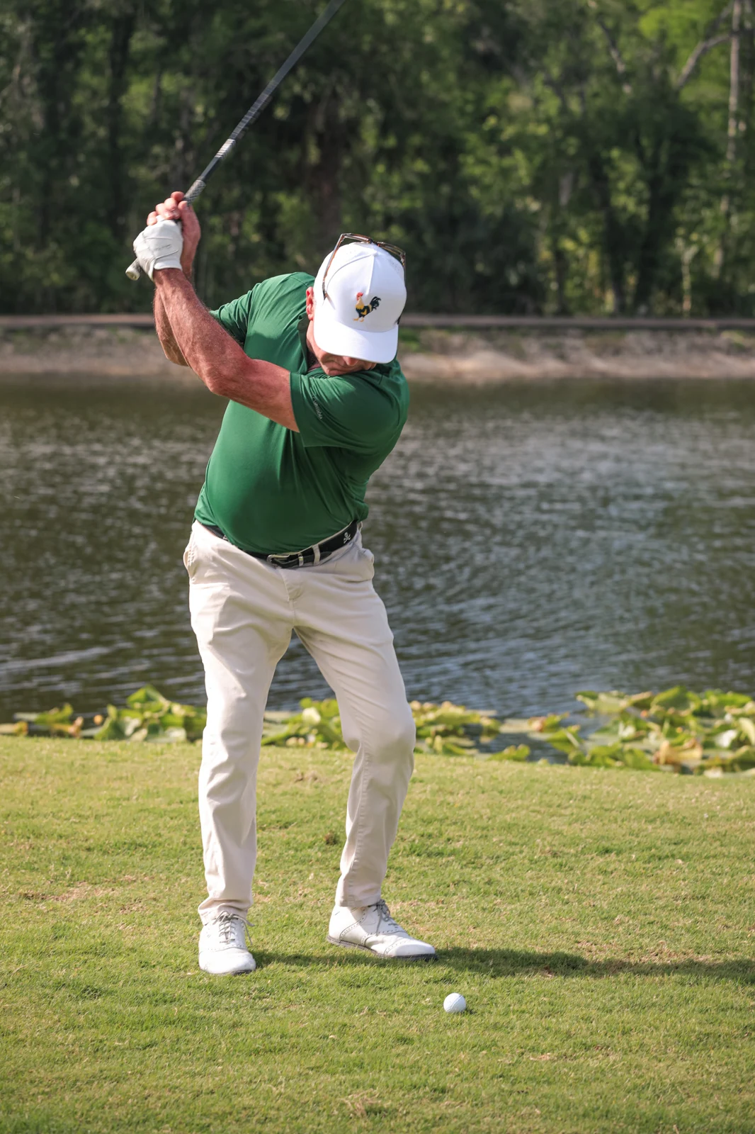 Golfer swinging beside the water